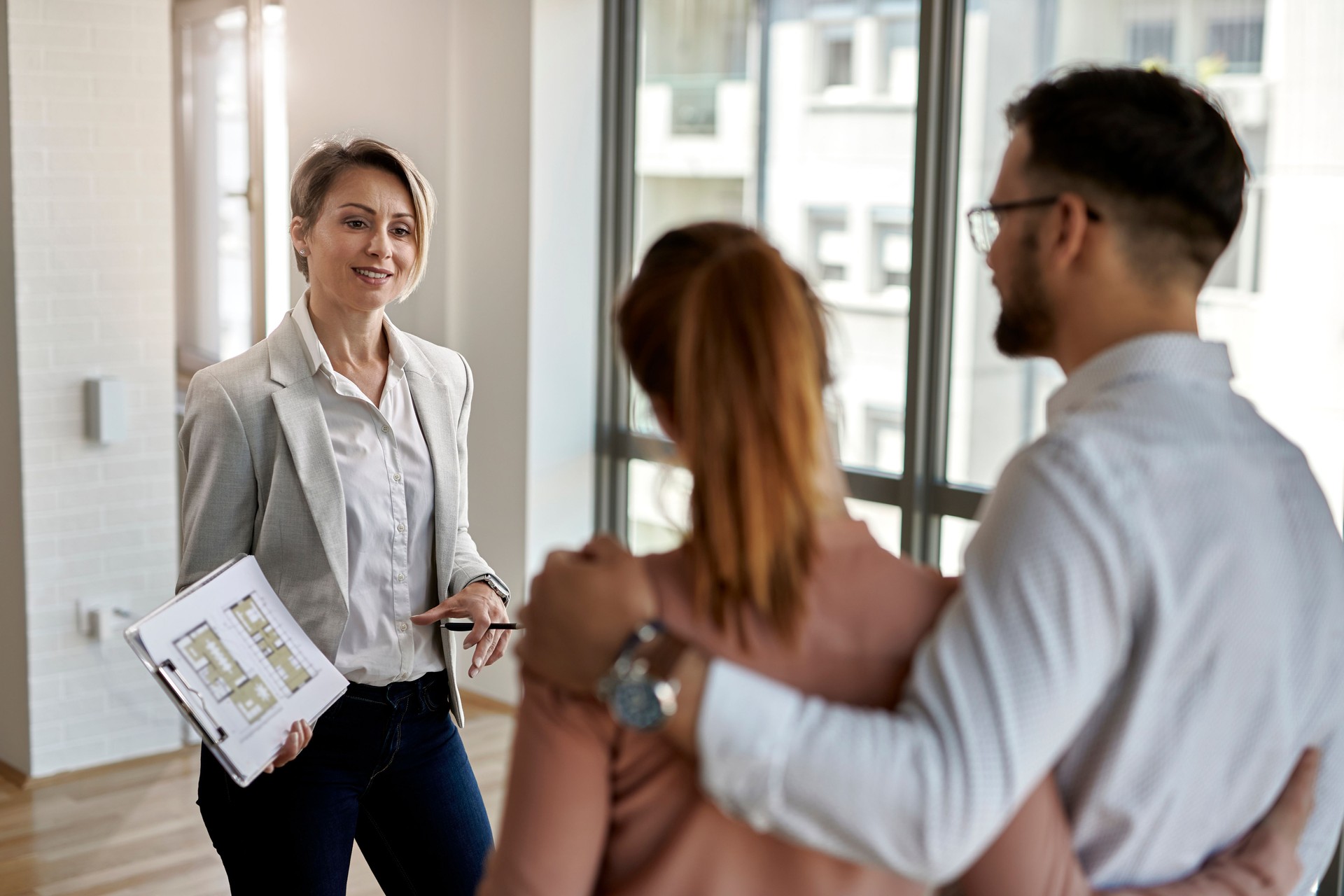 Real estate agent talking to a couple interested in buying new house.